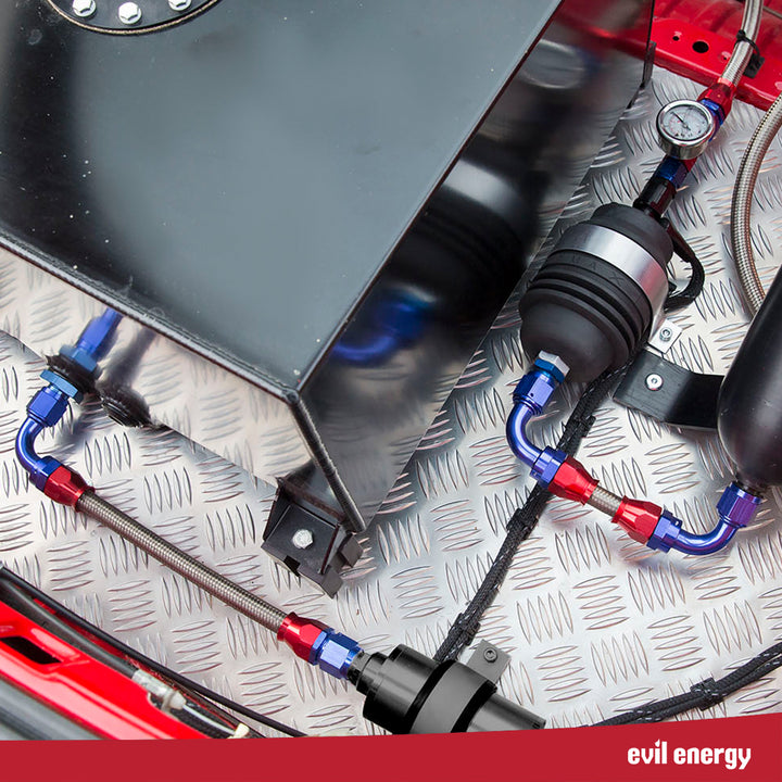EFI returnless fuel system setup installed in vehicle with braided fuel lines, fuel cell tank, and inline filter.